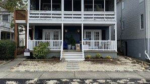 Une maison à deux étages avec un porche à l’avant, une pancarte indiquant « Vendu » et une autre pancarte indiquant « À vendre ».