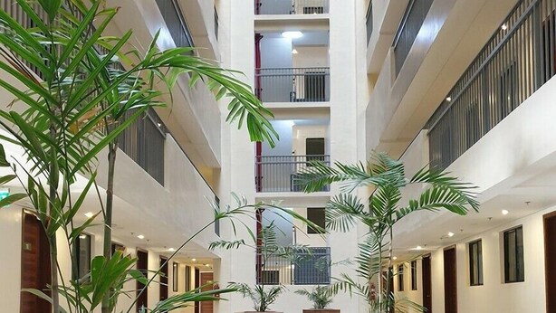 A multi-level atrium with wooden planters and a central staircase. - Soltana Nature Residence (Lapu-Lapu)