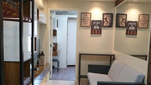 A modern bedroom with a bed, a wardrobe, and a ceiling fan. There are wall decorations and a hallway leading to another room. - Soltana Nature Residence (Lapu-Lapu)