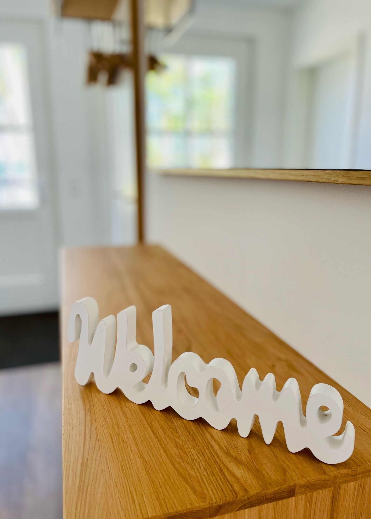 Un banco de madera con un cartel blanco que dice 'Welcome'.