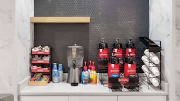 Un comptoir pour le petit-déjeuner, équipé de machines à café, de tasses à café et de divers condiments.