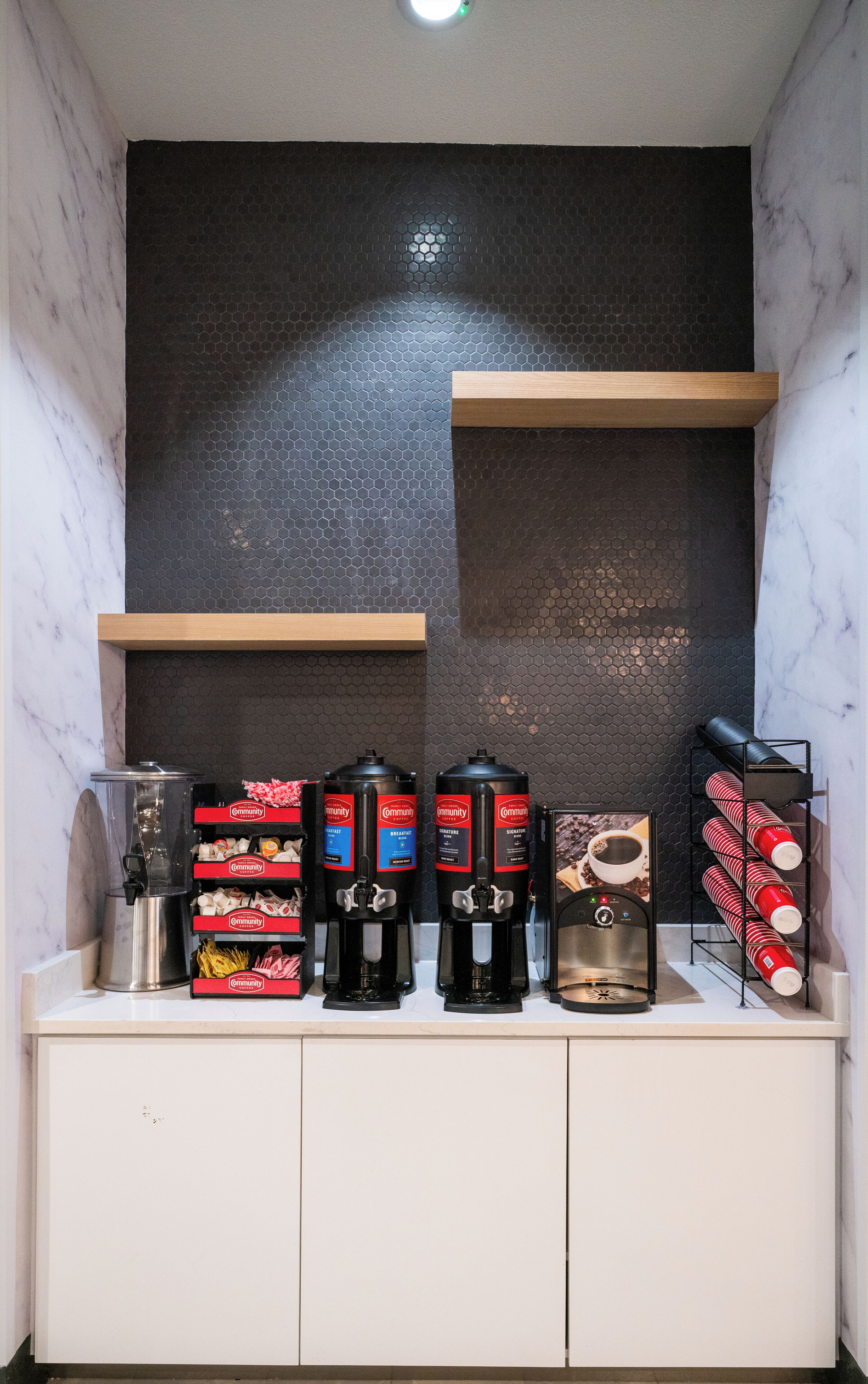 A coffee station with multiple coffee makers and branded coffee boxes.