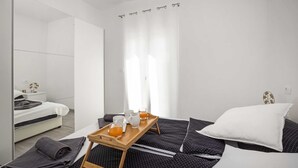 A modern bedroom with a bed, a wooden tray with drinks, a mirror, and a window with curtains. - Villa Marsel (4+2) - Private Pool and Jacuzzi (Gajana)