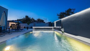 A modern outdoor pool area with a clear blue sky, a seating area with lounge chairs, and a potted plant. - Villa Marsel (4+2) - Private Pool and Jacuzzi (Gajana)