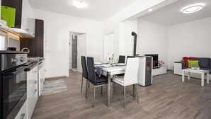 A modern kitchen with a dining area, a built-in oven, and a seating area with a sofa and a coffee table. - Villa Marsel (4+2) - Private Pool and Jacuzzi (Gajana)