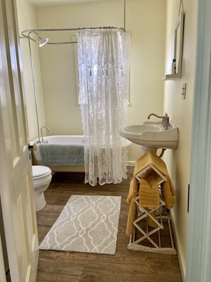 Une salle de bain équipée d’une baignoire, de toilettes, d’un lavabo et d’un rideau de douche.