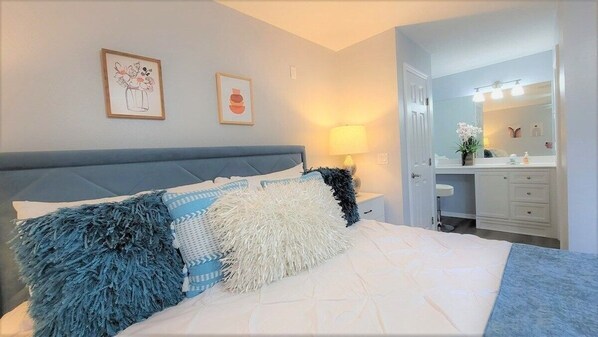Un dormitorio con cama, mesita de noche, lámpara, cómoda y espejo.