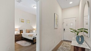 Ein Flurzimmer mit Bett, Nachttischen, einer Lampe und einem Spiegel.