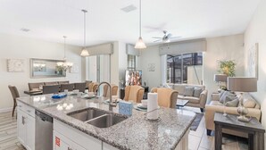 A modern kitchen with granite countertops, a built-in dishwasher, and a central island with a sink.