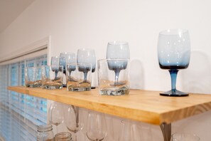 Un estante de madera con varios vasos y frascos.