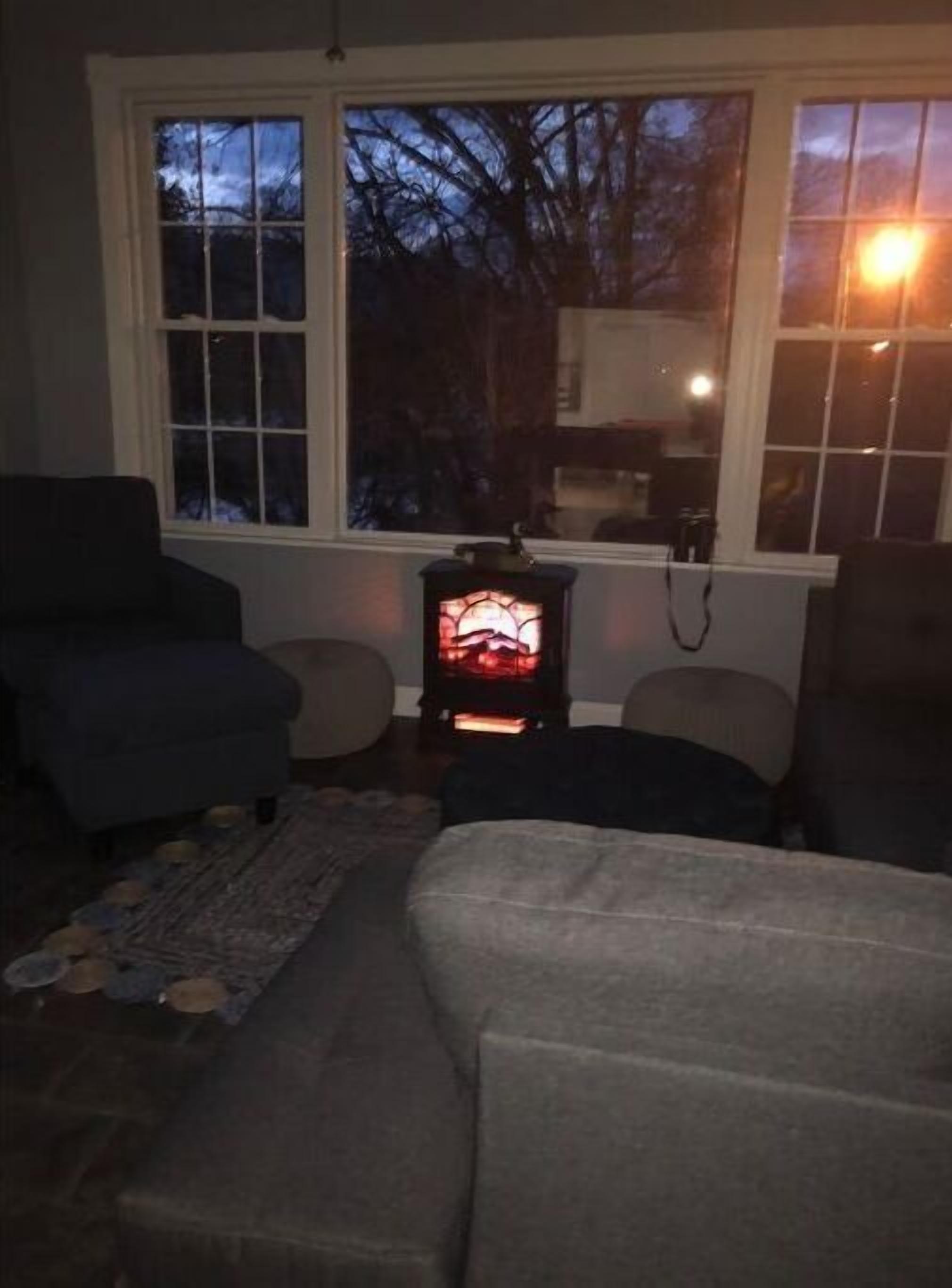 Ein gemütliches Wohnzimmer mit Kamin, Sofa und Sessel.