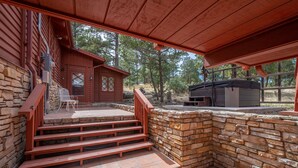 A wooden cabin with a stone staircase leading to a deck, a covered seating area, and a grill. - Private property, located on a cul-de-sac, jacuzzi, deck, outdoor activities (Alto)