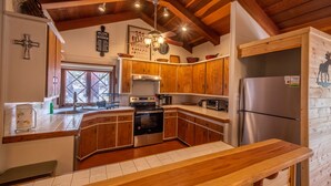 A kitchen with wooden cabinets, a stainless steel refrigerator, and a wooden countertop. - Private property, located on a cul-de-sac, jacuzzi, deck, outdoor activities (Alto)
