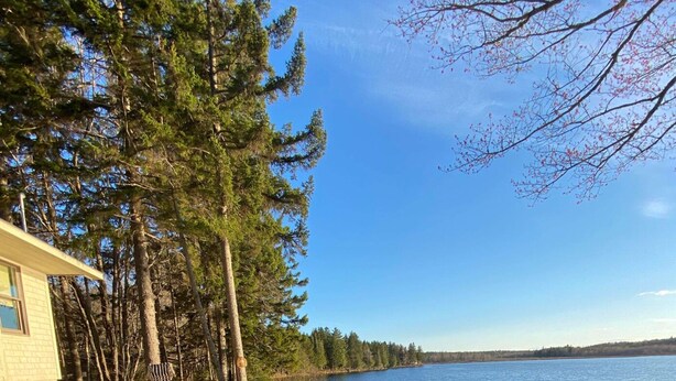 Un chalet au bord du lac, doté d’un espace extérieur aménagé et d’un foyer.