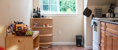 A kitchen with wooden cabinets, a window, and a countertop with a kettle.