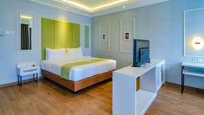 A modern hotel room with a bed, bedside table, TV, and a desk. - Hotel Dafam Enkadeli Thamrin Jakarta (Jakarta)