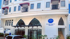 A multi-story hotel with balconies, a central entrance, and a sign indicating it is located in Jakarta. - Hotel Dafam Enkadeli Thamrin Jakarta (Jakarta)