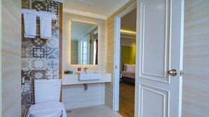A bathroom with a toilet, sink, and mirror. - Hotel Dafam Enkadeli Thamrin Jakarta (Jakarta)