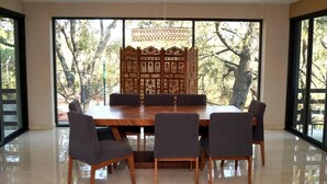 A dining area with a wooden table, six chairs, and a decorative partition with intricate patterns.