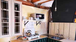 A compact kitchen with a gas stove, a microwave, and a sink. - Cities Of the World - Cusco City Views (Cusco)