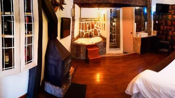 Habitación de hotel con una cama, un pequeño rincón de descanso y una pared con diseño decorativo.