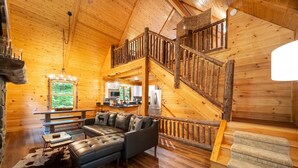 A log cabin interior with a loft bedroom, a dining area, and a kitchen. - Luxury ADK Retreat Near Whiteface, Lake Placid (Jay)