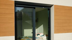 A bedroom with a bed, a window, and a door. - Contemporary house at the gates of Brest (BOHARS)