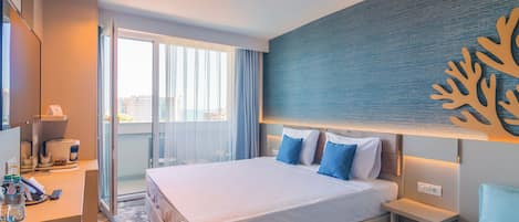 A hotel room with a bed, bedside tables, a desk with a coffee machine, and a view of the outside.