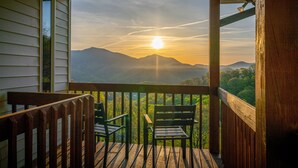 A wooden deck with two chairs facing a scenic mountain view at sunset. - 14 Acres - Theater Room - 20 Miles to DT Asheville - Paved Drive the whole way! (Canton)