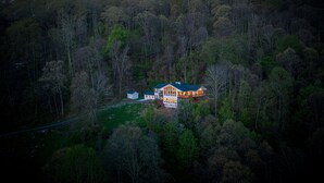A large house surrounded by dense forest, with a visible driveway and a small building to the left. - 14 Acres - Theater Room - 20 Miles to DT Asheville - Paved Drive the whole way! (Canton)