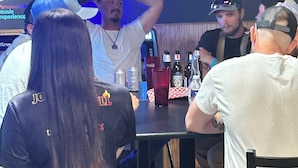 Una zona de bar con mesas, sillas y una barra.