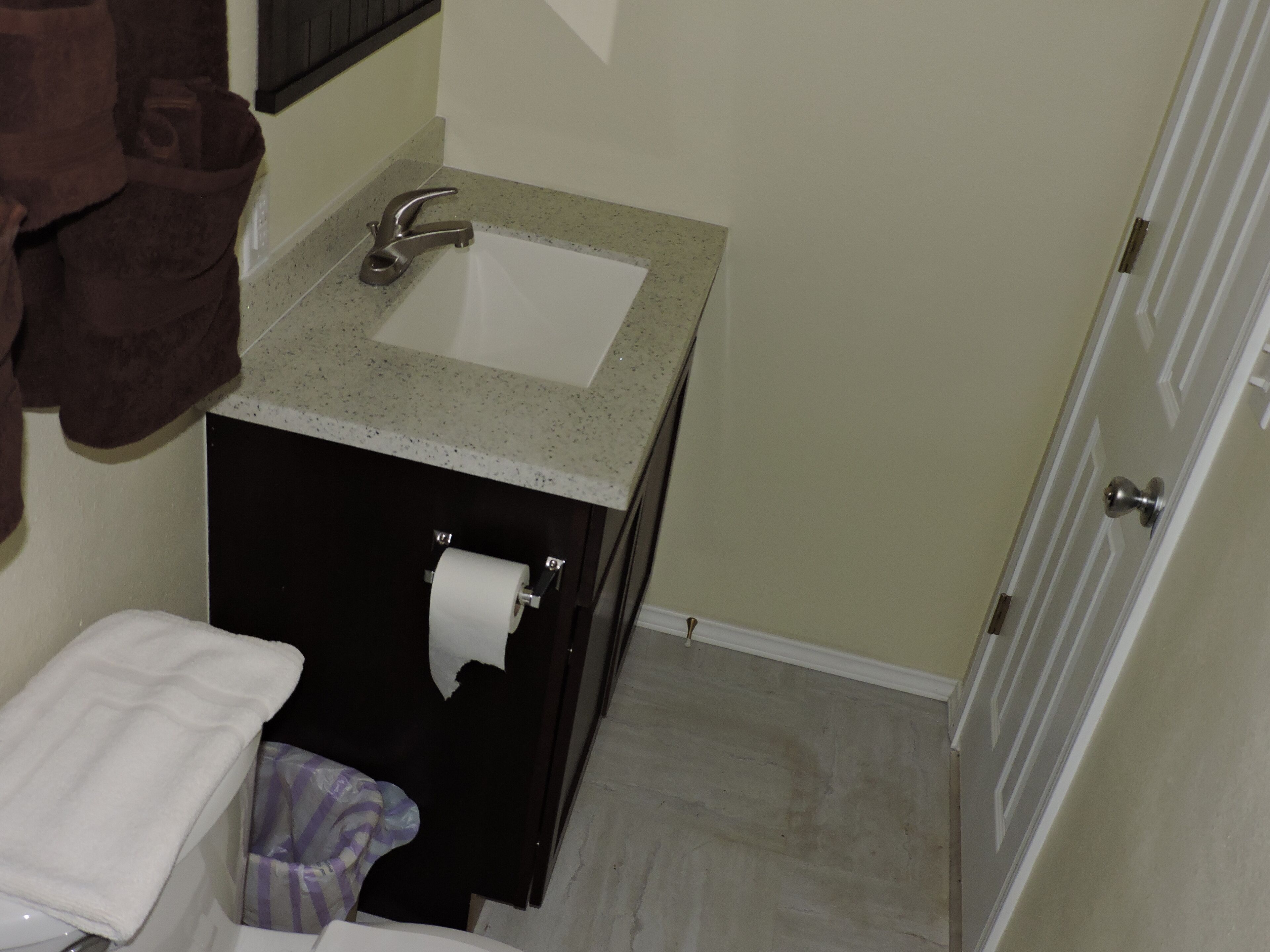 A bathroom with a sink, toilet, and towel rack.