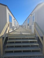 Una fila de casas móviles blancas con escalones de madera que conducen a la entrada.