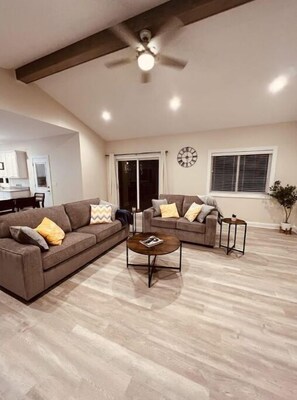 Relax in this spacious living room with a large sofa, round coffee table, and side table.