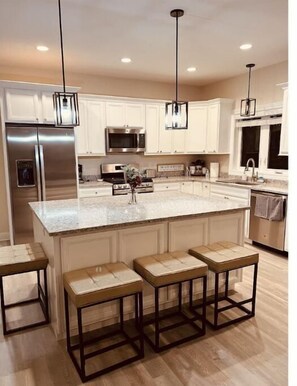 Enjoy cooking in this well-equipped kitchen with a central island and stainless steel appliances.
