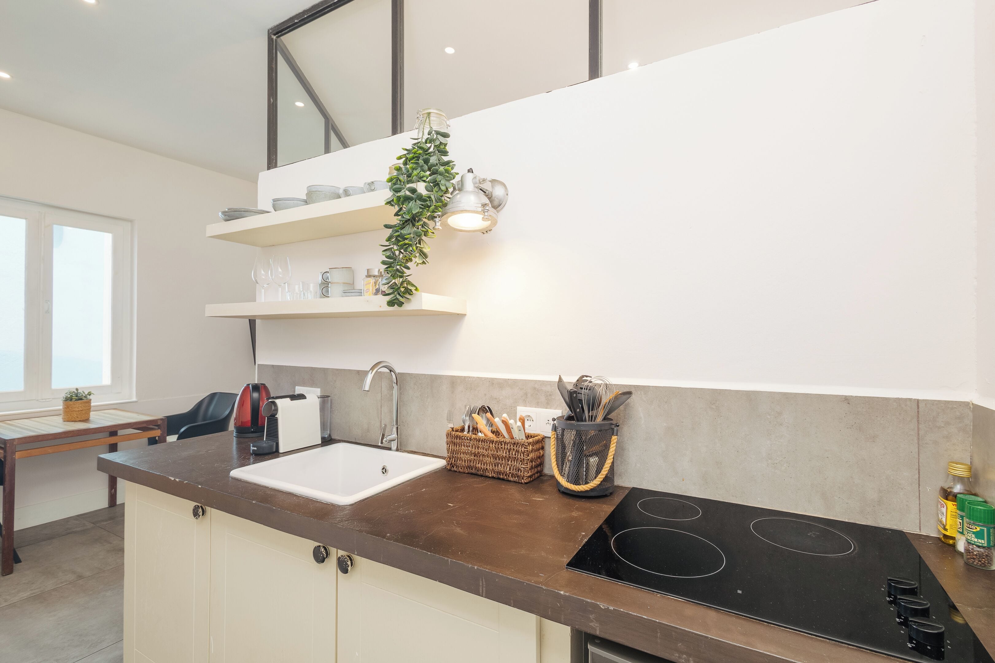Una cocina moderna con estufa integrada, un lavamanos y un ventanal.