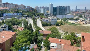 A cityscape with a mix of residential and commercial buildings, a winding road, and a construction site. - Sahrakent Otel Kadıköy  (Istanbul)