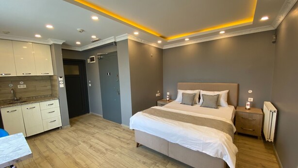 A modern bedroom with a large bed, bedside tables, and a built-in wardrobe. - Sahrakent Otel Kadıköy  (Istanbul)