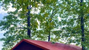 A wooden cabin with a red roof, a wooden deck, and a sign that reads "HONEYMOONER".