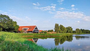 A house with a red roof and a pond in front. - Gorgeous home in Heinkenszand with WiFi (Heinkenszand)