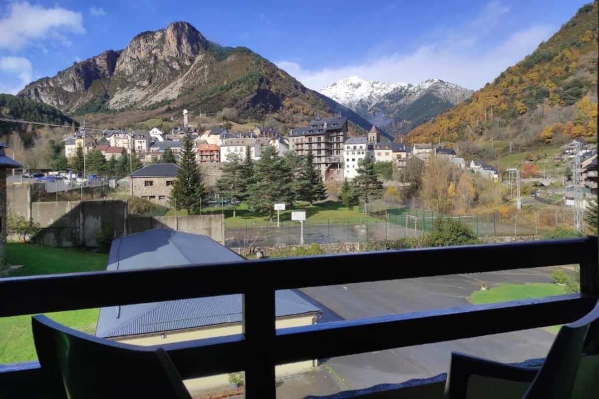 A mountainous town with buildings and a view of snow-capped peaks.
