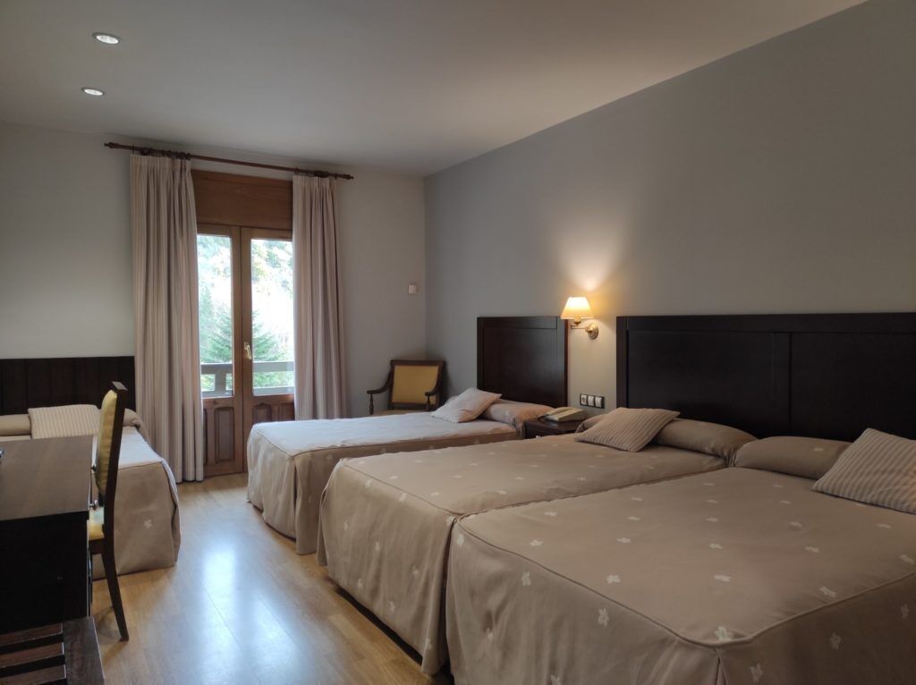 Une chambre d’hôtel avec deux lits, un bureau et une chaise.