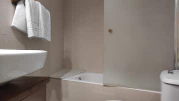 Een badkamer met een wit wastafel, een bad en een toilet.