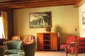 A living room with a wooden cabinet, two leather chairs, and a framed picture on the wall. - Snö Bielsa (Bielsa)