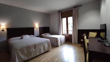 Habitación de hotel con dos camas, un escritorio y una silla.