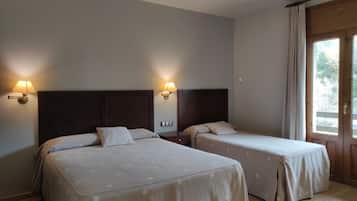 Una habitación de hotel con dos camas, cada una con cabecera y lámparas de noche.