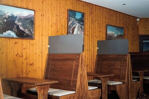 A room with wooden panel walls, a wooden bench seating area, and framed pictures of mountainous landscapes. - Snö Bielsa (Bielsa)