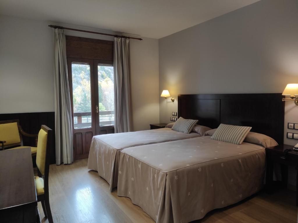 Una habitación de hotel con dos camas, un escritorio y una silla.