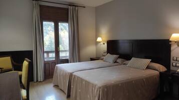 Una habitación de hotel con dos camas, un escritorio y una silla.