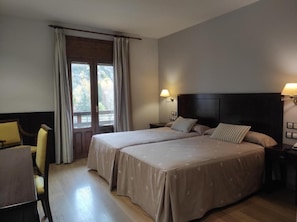 A hotel room with two beds, a desk, and a chair. - Snö Bielsa (Bielsa)